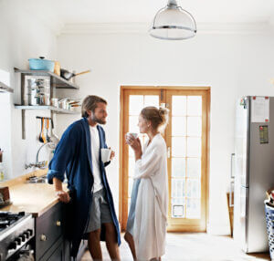 Ett par står i köket med en kopp i handen och övar på aktivt lyssnande.